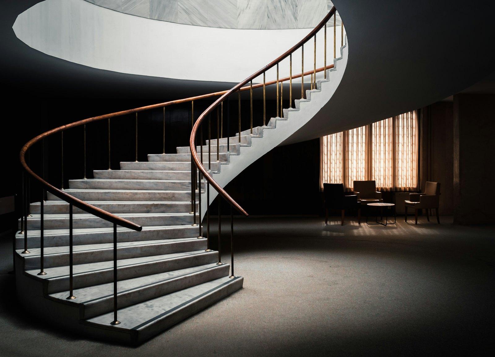 Un escalier de marbre incurvé à la rampe de laiton